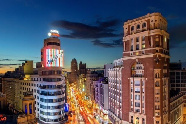 Como Viajar do Brasil a Madrid : Vista panorâmica noturna da Gran Vía em Madrid com luzes de trânsito em movimento e arquitetura histórica espanhola iluminada, ideal para brasileiros planejando viagem econômica à Europa