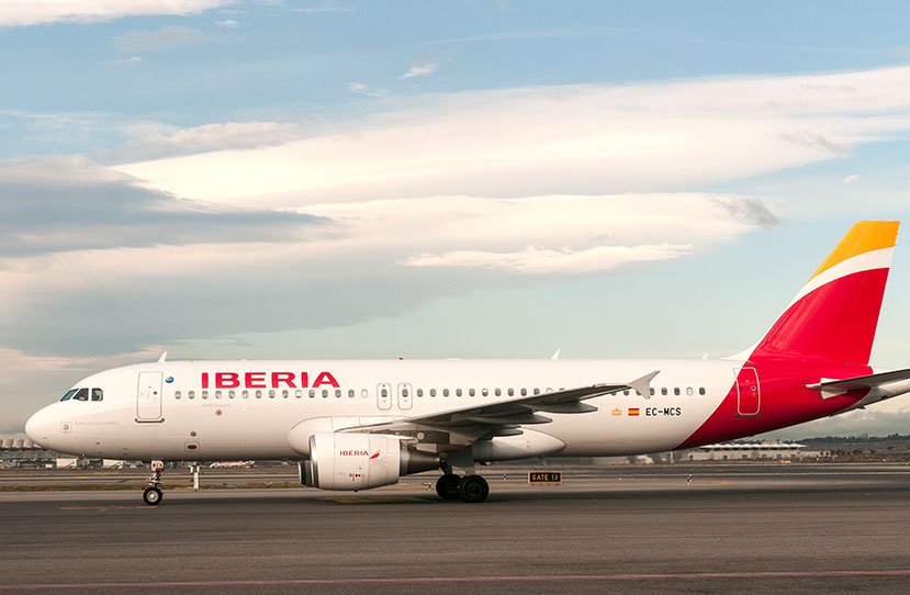 Como é Viajar pela Iberia: : Avião da Iberia estacionado no aeroporto mostrando como é viajar pela Iberia