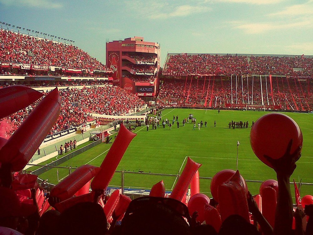 Torcida vibrando no Estádio Libertadores de América, em Buenos Aires, durante uma partida de futebol lotada