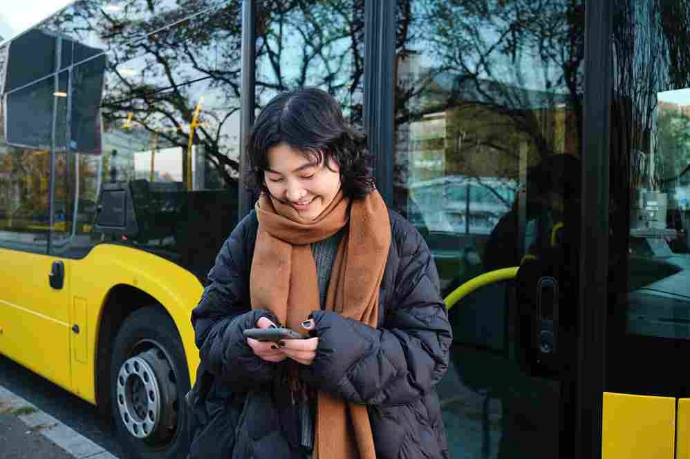 "Jovem viajante usando smartphone planilha orçamento transporte público sudeste asiático apps viagem economia"