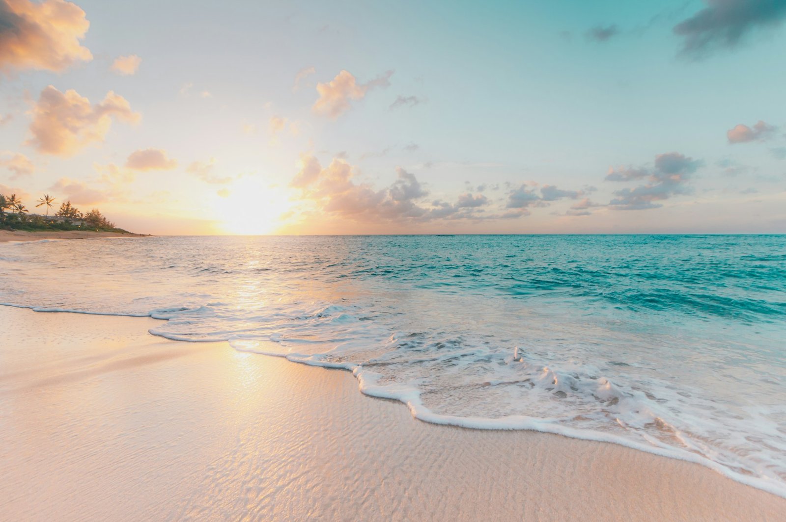 Casal romântico caminhando na praia de Nungwi ao pôr do sol, com águas turquesa e areia branca