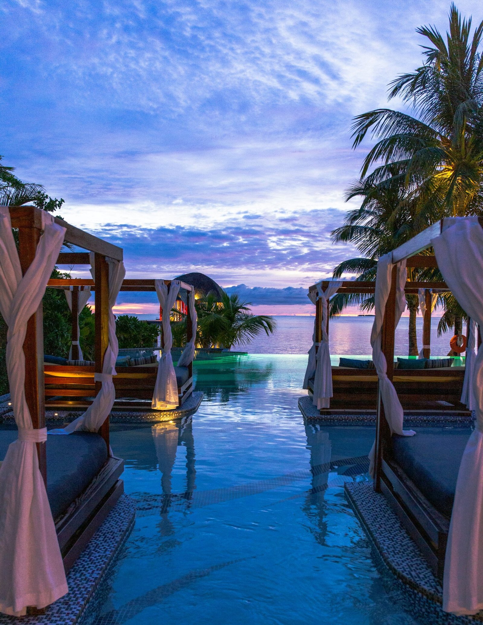 Resort de luxo Zanzibar com piscina infinity vista oceano e palmeiras tropicais